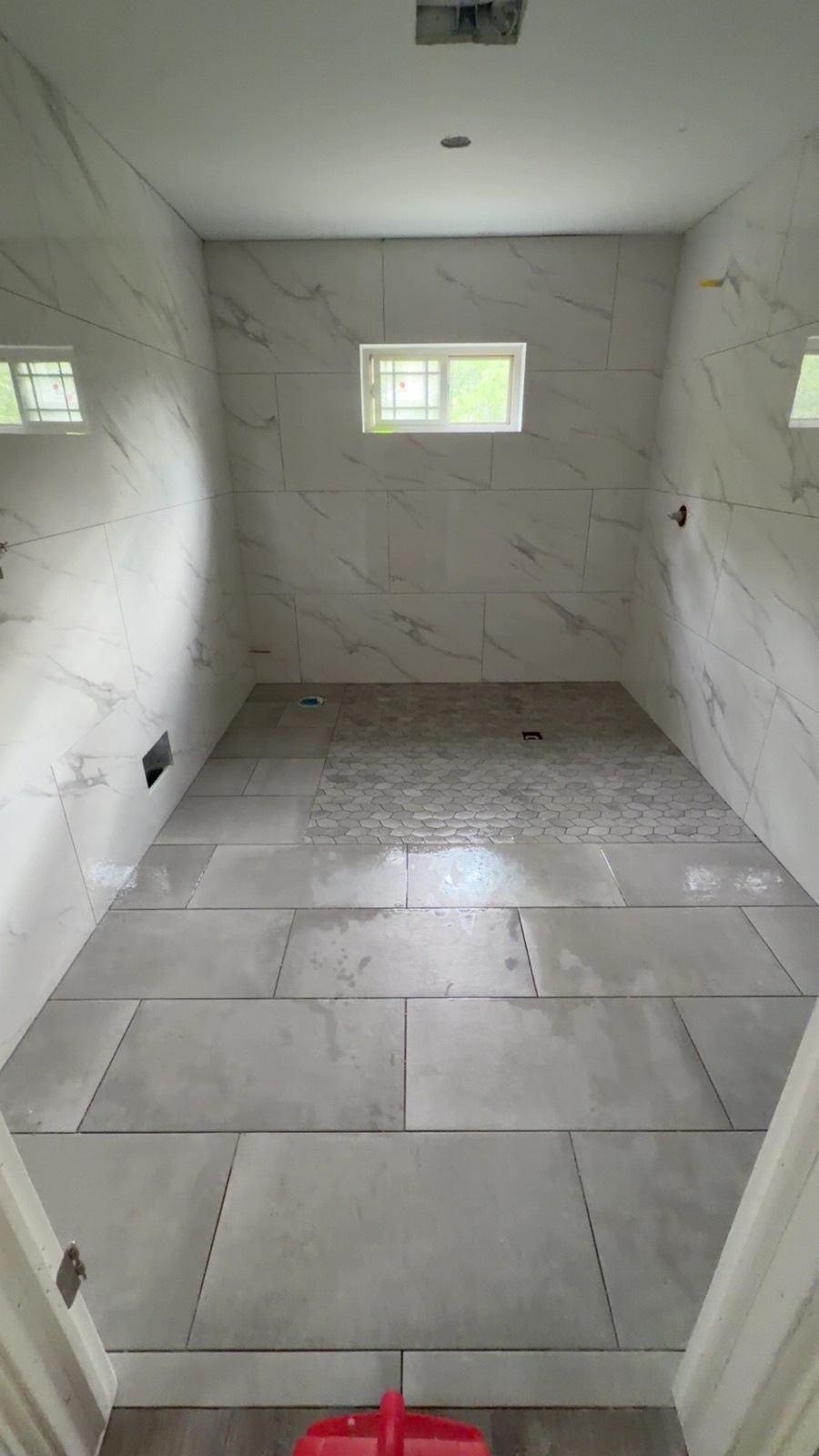 Book-matched marble walk-in shower with mosaic floor