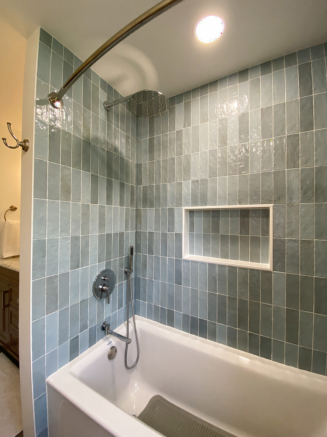 The finished green stacked-tile tub surround with a centered niche